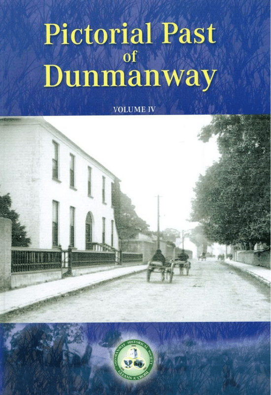 Book cover for "Pictorial Past of Dunmanway VOLUME IV". The background is blue with dark silhouette branches at the top. A sepia photograph shows a wide street with a large white building on the left, several horse-drawn carts, and trees. The Dunmanway Historical Association logo is at the bottom centre.