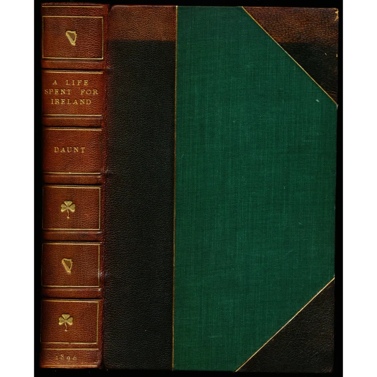 The cover and spine of a vintage leather-bound book from 1896, written by Daunt. The spine is made of rich brown leather divided into panels by gold-leaf borders. The text on the spine reads "A LIFE SPENT FOR IRELAND", "DAUNT", and the year "1896" at the bottom, interspersed with small gold-stamped icons of a traditional Irish harp and shamrocks. The front cover features a dark brown leather border and a prominent textured forest green cloth centre.