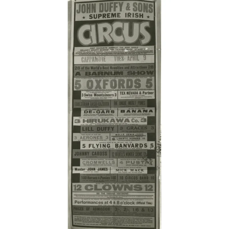 A long, vertical black and white photograph of a detailed 1940 circus playbill for John Duffy & Sons Supreme Irish Circus. Stamped near the top for a visit to "CAPPAMORE TUES. APRIL 9", the text-heavy flyer promotes "A Barnum Show" featuring an extensive list of acts including "5 Oxfords International Cycling Stars", "3 Hirukawa Co. Wonderful Japanese Performers", and "Lill Duffy Hurricane Horse Act Riders".
